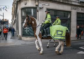 Police officers riding horses through a high street in Cardiff 