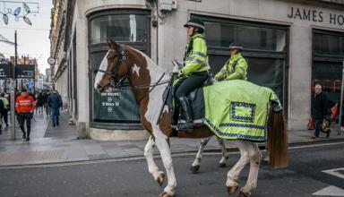 Police officers riding horses through a high street in Cardiff 