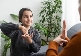 Delwedd o blentyn yn arwyddo gyda pherson arall