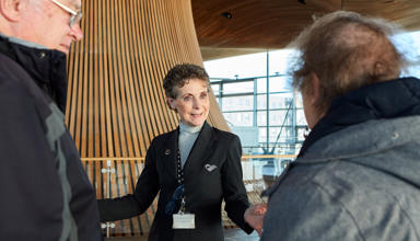 Tywysydd yn tywys pobl ar daith o amgylch y Senedd