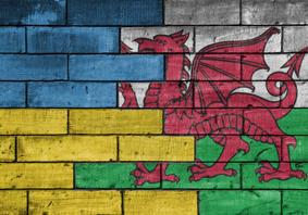 blociau pren wedi'u paentio fel baneri Cymru ac Wcráin yn cwrdd yn y canol 
