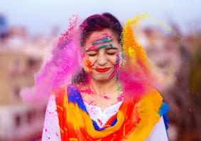 Mae prif ddelwedd yr erthygl yn dangos person hapus yn dathlu gŵyl Holi yn India gyda phowdrau lliw.