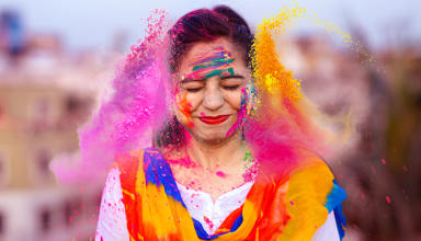 Mae prif ddelwedd yr erthygl yn dangos person hapus yn dathlu gŵyl Holi yn India gyda phowdrau lliw.