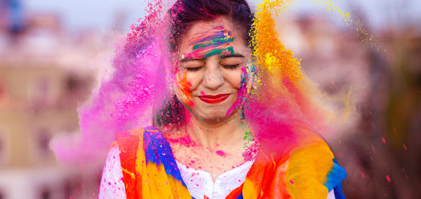 Mae prif ddelwedd yr erthygl yn dangos person hapus yn dathlu gŵyl Holi yn India gyda phowdrau lliw.