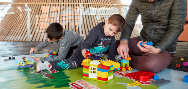 Rhiant a phlant yn chwarae gyda blociau adeiladu ym man chwarae'r Senedd