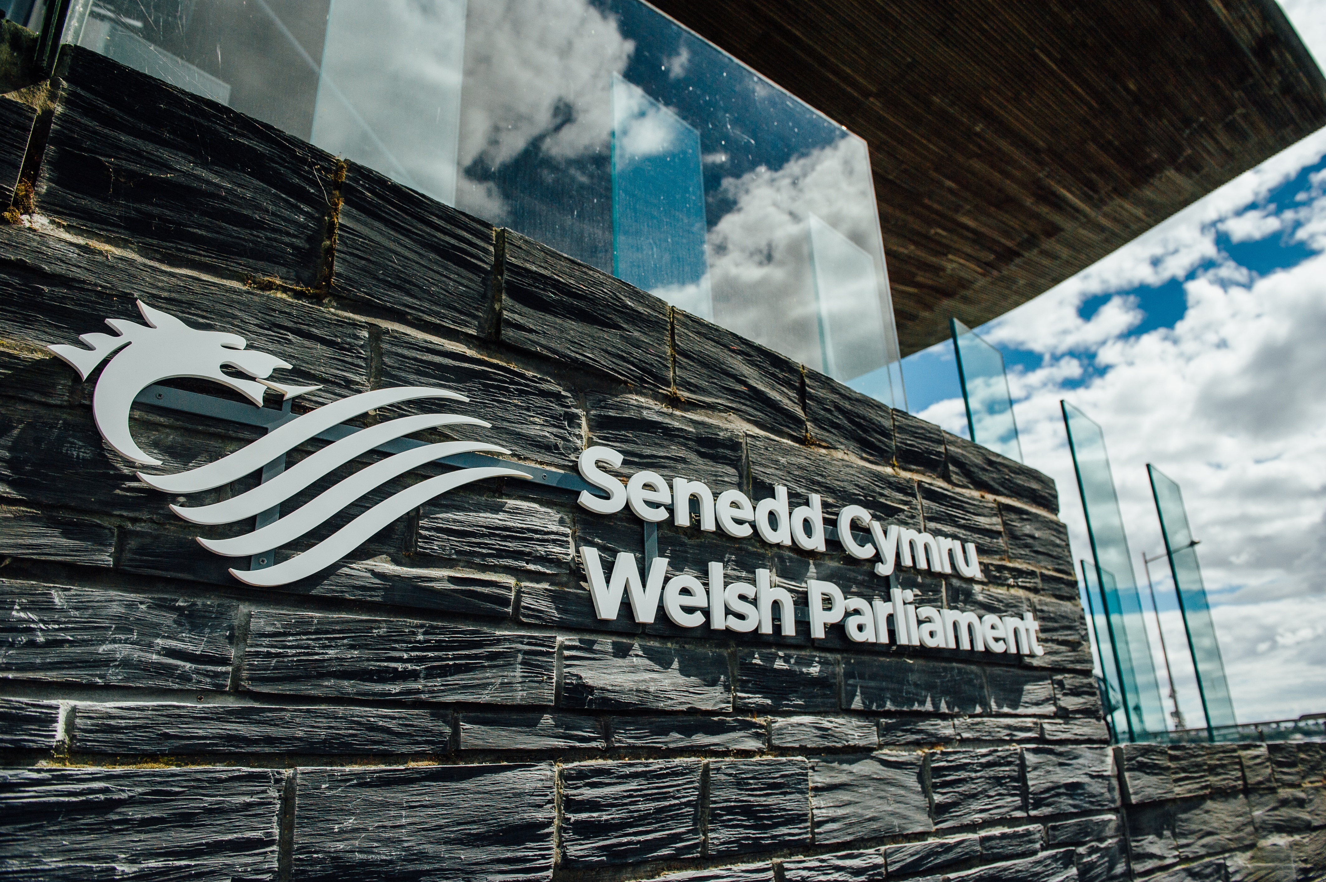 Arwydd Senedd Cymru - Welsh Parliament y tu allan i adeilad y Senedd