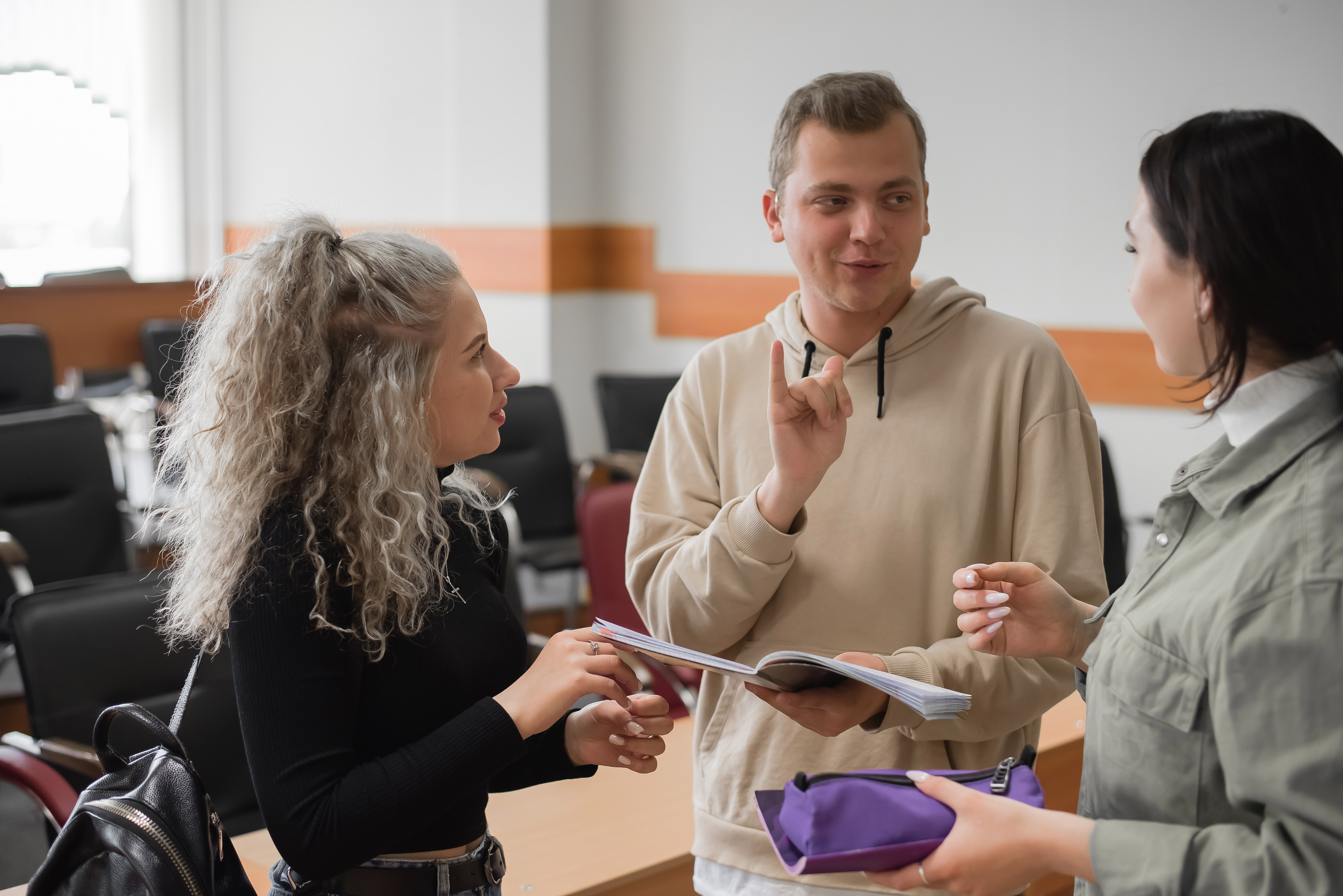 Image of three young people signing to each other