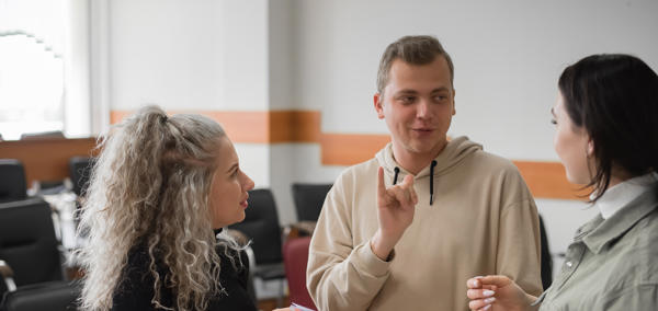 Image of three young people signing to each other