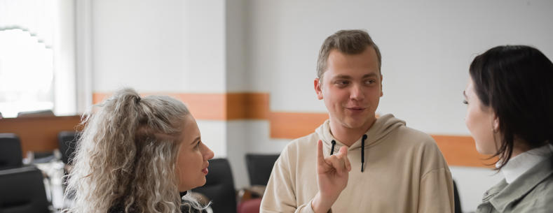Image of three young people signing to each other