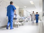 Coridor ysbyty, mae nyrsys yn siarad ac yn gofalu am gleifion